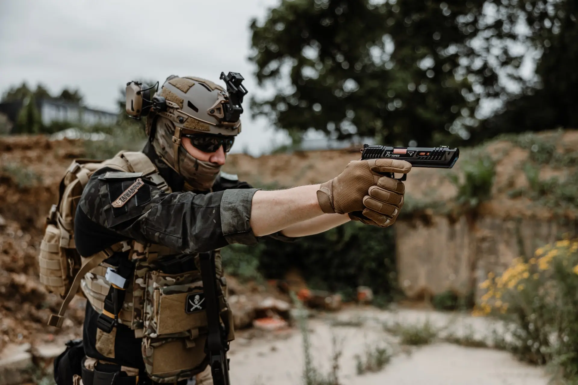 a man in camouflage holding a gun in his hand